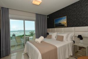 邦比尼亚斯Hospedaria Home Suites Mariscal的一间卧室设有一张床,享有海景