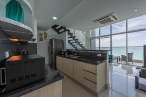 卡塔赫纳MURANO ELITE NEW OCEAN FRONT DUPLEx的厨房配有水槽、冰箱和楼梯。