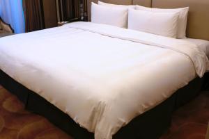 曲阜曲阜香格里拉的一张白色大床,配有白色床单和枕头