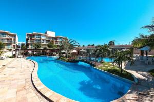 阿奎拉兹Palm Beach | Porto das Dunas - CE的度假村的游泳池,种植了棕榈树,设有公寓