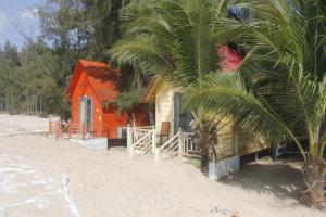 罗夷宝安日落海滩度假村的棕榈树旁海滩上的房子