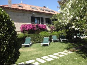 维戈Hotel Playa Samil Vigo的坐在院子里草地上的一组椅子