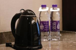 曲阜曲阜香格里拉的咖啡壶和柜台上的两瓶水