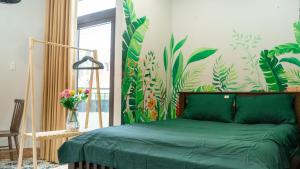 胡志明市Cherry Apartment - Thao Dien Centre的一间卧室配有一张绿色的床,并拥有热带壁纸