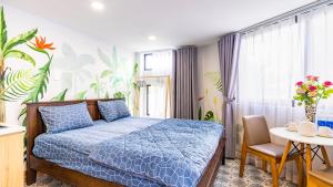 胡志明市Cherry Apartment - Thao Dien Centre的一间卧室配有蓝色的床、一张桌子和一个窗户。