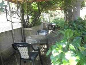 维戈Hotel Playa Samil Vigo的花园里的一组椅子和一张桌子