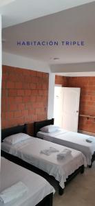 努基Hotel OBEGA PACIFIC的红色砖墙客房的两张床