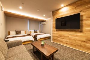 长崎GRAND BASE Urakami的酒店客房设有两张床和一台平面电视。