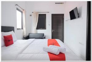 雅加达RedDoorz near Kota Tua 2的卧室配有带红色枕头的大型白色床