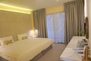 拉廊Sook Hotel的一间设有大床和窗户的酒店客房