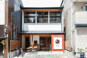 福冈Fukuoka Guesthouse HIVE的一座带橙色门和大楼的房子
