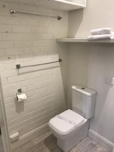 贝尔蒙特Belmont Palms Motel的白色的浴室设有卫生间和架子。