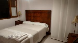 Ampudia拉斯卡西塔斯德帕佩尔酒店的卧室配有白色的床和木制床头板