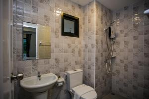 佛统โรงแรมกอดหมอน的一间带水槽、卫生间和镜子的浴室