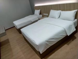 马六甲Maple Boutique Hotel的配有2张床的带白色床单和枕头的客房
