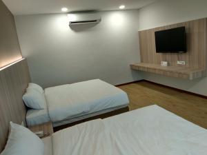马六甲Maple Boutique Hotel的一间酒店客房,配有一张床和一台电视
