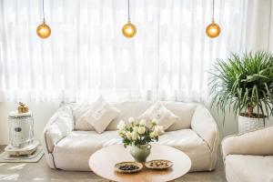 大理远山青·Stone Hill自家海景客栈的客厅配有白色的沙发和桌子