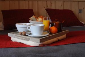 阿热莱斯加佐斯特Auberge Le Cabaliros的床上的托盘,包括早餐食品和饮料