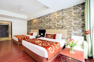 甘托克The Fern Denzong Hotel & Spa Gangtok, Sikkim的一间卧室设有两张床和砖墙