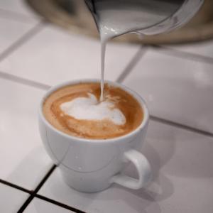 胡斯克瓦纳胡思克瓦纳城市酒店的一杯咖啡,牛奶倒入其中