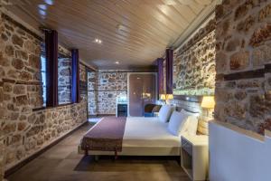 安塔利亚Puding Hotel的一间卧室设有一张床和石墙