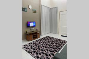 樟仑Twilight Imani Homestay Changlun的一间带电视和地毯的客厅