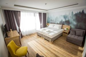 科帕奥尼克SREBRNA PLANINA Spa & Resort的一间卧室配有一张床、一张沙发和一把椅子