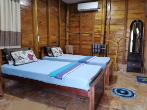 KalladySea View Resort的木墙客房的两张床