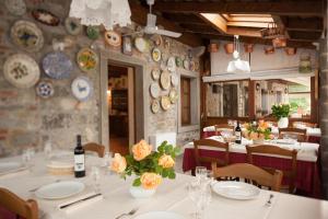 Nimis柯美丽农家乐的一间墙上设有白色桌子和盘子的用餐室