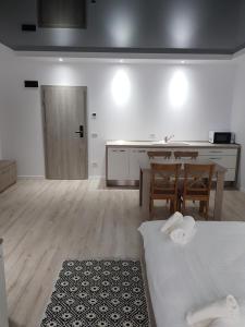 上维谢乌Happy Residence的客房设有厨房、桌子和床。