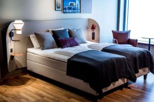 哥本哈根科德恩斯堪迪克酒店的一间卧室配有一张带紫色枕头的大床