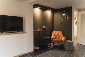 PosterholtVakantie-appartement Oppe Donck met sauna的客厅配有椅子和平面电视