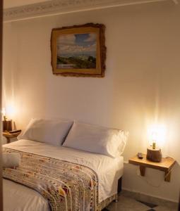 佩雷拉NOGAL HOSTEL的卧室配有一张床,墙上挂有绘画作品
