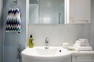 赫尔辛基Central, peaceful, high-end apartment的浴室设有白色水槽和镜子