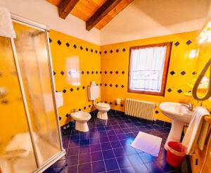 萨帕达瓦尔捷肯达酒店的黄色的浴室设有2个卫生间和淋浴