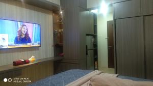 芝卡朗Apartemen Riverview Residence Jababeka at KiNGDOM Rent Apartment Solution的一间带电视和一张床的卧室