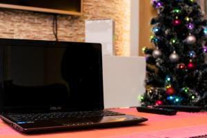 尼什Apartment Aleksija的手提电脑坐在圣诞树旁边的桌子上