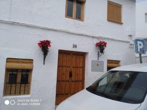 苏埃罗斯Casita tipica的停在一座红花建筑前面的汽车