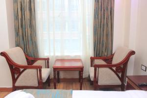 纳库鲁Vickmark Hotel的一间设有两把椅子、一张桌子和一个窗户的房间