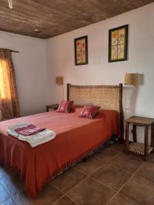 普尔马马尔卡La Posada de la Calandria的一间卧室配有一张红色床罩的床