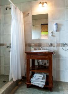 埃尔卡拉法特拉森宾馆的浴室配有盥洗盆和带镜子的淋浴