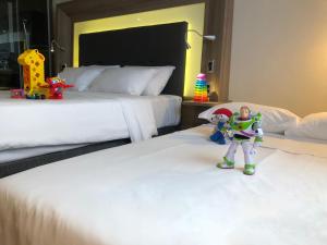 圣保罗Novotel São Paulo Berrini的酒店客房设有两张带玩具雕像的床。