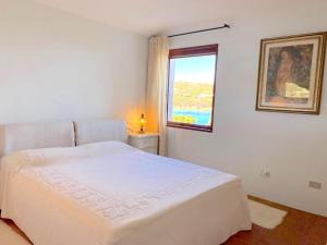 切尔沃港Sea & Beach Apartments Porto Cervo Costa Smeralda的白色的卧室设有床和窗户