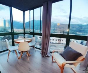 比利亚努阿el rincon de collarada的客房设有桌椅和大窗户。