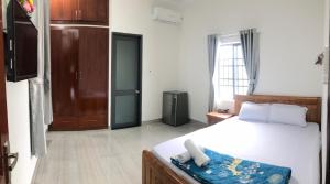 头顿Motel Thân Thiện 2的一间卧室配有一张床,一扇门通往一个房间