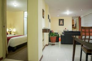 阿雷基帕英卡明公寓式酒店的一间卧室配有一张床和一个沙发