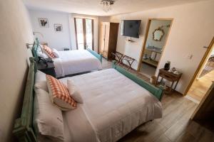 SanteaguedaVilla Toscana ValQuirico Lofts & Suites Hotel Boutique的酒店客房设有两张床和电视。