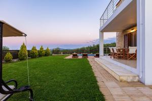AngelianaDimokritos Villas, a homestay experience, By ThinkVilla的后院设有庭院和草坪