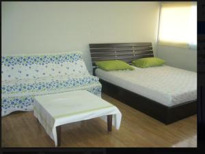 Ban Bang PhangFamily Room Dmk Don mueang Airport 2 bedrooms的一间卧室配有两张床、一张长凳和一张桌子