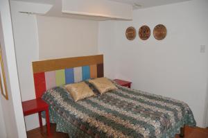 安蒂波洛佳期美食度假酒店的一间卧室配有一张带五颜六色棉被的床